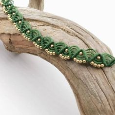 a piece of wood that has some kind of green beaded bracelet on top of it