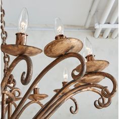 a wooden chandelier with five lights hanging from it's arms and filigrees