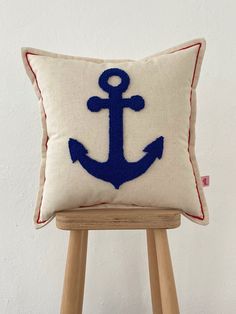 an anchor pillow sitting on top of a wooden stool