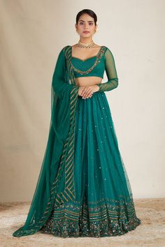 Teal green attached can can lehenga with floral embroidery in sequin, cutdana and nakshi. Paired with embroidered, padded blouse and embroidered border dupatta.
Components: 3
Pattern: Embroidered
Type Of Work: Nakshi, Cutdana, Sitara
Neckline: Sweetheart
Sleeve Type: Sheer
Fabric: Nylon, Net, Crepe
Color: Green
Other Details: 
Floral pattern
Lehenga Length: 44 inches
Note: Saree set and potli bag held by the other model is not for sale
Occasion: Bride,Wedding - Aza Fashions Festive Green Lehenga With Sheer Dupatta, Green Choli For Reception With Traditional Drape, Green Dola Silk Choli With Sheer Dupatta, Green Choli With Cutdana For Reception, Party Wear Green Lehenga With Resham Embroidery, Green Resham Embroidery Lehenga For Party Wear, Designer Green Choli With Sheer Dupatta, Green Choli For Eid Reception, Green Unstitched Anarkali Set For Party