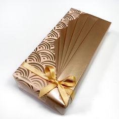 an open gift box wrapped in brown paper with gold ribbon