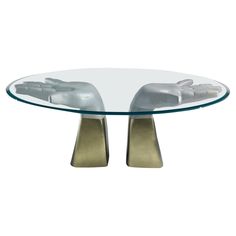 a glass table with metal legs and two hands on each end, in front of a white background