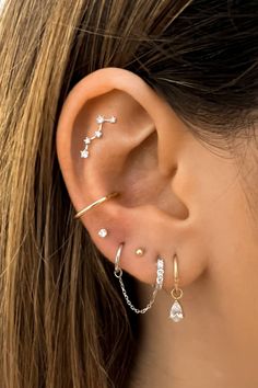 a woman's ear with three different piercings