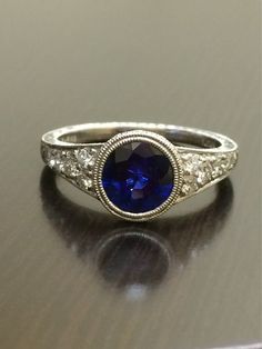 DeKara Designs Collection An Art Deco Platinum Ceylon Blue Sapphire breathtaking ring that must be seen in person to be appreciated.  Metal- 90% Platinum, 10% Iridium.Stones- 1 Round Ceylon Blue Sapphire, 1.83 Carats.  10 Round Diamonds, G color VS1 clarity, 0.36 Carats.  The craftsmanship on this ring is impeccable, and will look extraordinary on a true art lovers finger.  You will wear this ring with great joy, and love.  You will keep glancing at it because it will distract you so much!  Plea Classic Sapphire Diamond Ring Gia Certified, Gia Certified Sapphire Diamond Ring In Timeless Style, Gia Certified Timeless Sapphire Diamond Ring, Exquisite Sapphire Diamond Ring Gia Certified, Dazzling Sapphire Rings Gia Certified, Exquisite Gia Certified Sapphire Diamond Ring, Exquisite Diamond-cut Sapphire Ring, Exquisite Diamond Cut Sapphire Ring, Classic Gia Certified Platinum Sapphire Ring