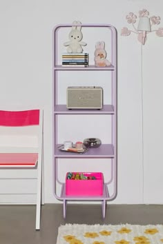 a room with a pink chair and purple shelf