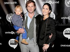 a man, woman and child standing in front of a red carpet