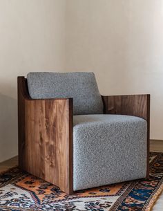 a gray chair sitting on top of a rug