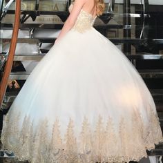 a woman in a wedding dress standing on stairs