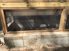 an animal cage in the back of a house with wood and wire around it's sides