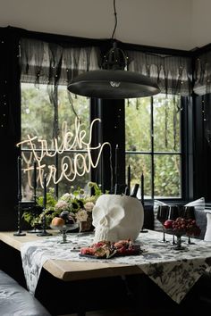 a dining room table with a light up sign above it