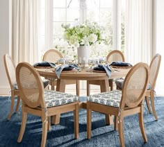 a dining room table and chairs with blue carpet