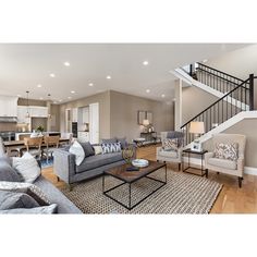 a living room filled with furniture and a stair case in front of the couches