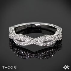 a wedding band with white diamonds on it and the words tacori written in black