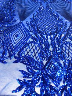 blue sequins are arranged on a white cloth