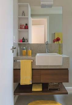 a bathroom sink with yellow towels on the counter