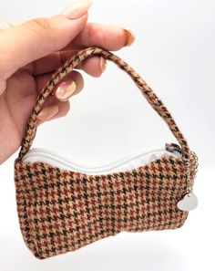 a hand holding a small purse made out of fabric