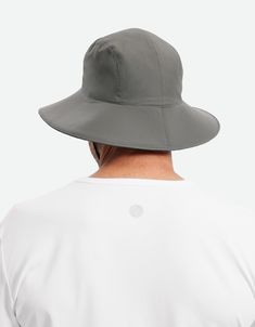 a man wearing a white shirt and grey hat looking at the back of his head