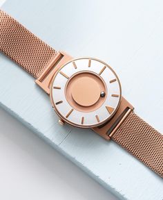 A photo shows the strap lying on a flat surface. One part has a fixed clasp and the other part has an adjustable clasp for a custom fit. Modern Rose Gold Watch For Everyday Use, Warm Tone, Golden Glow, Stainless Steel Mesh, Steel Mesh, A Rose, Gold Watch, Time Piece, Markers