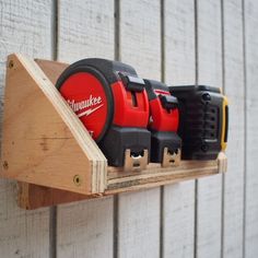 a wooden shelf holding several different types of drillers on it's side wall