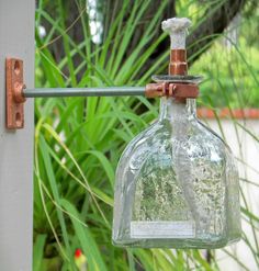 a glass bottle hanging from a metal hook