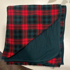 a red and black plaid blanket folded on top of a table