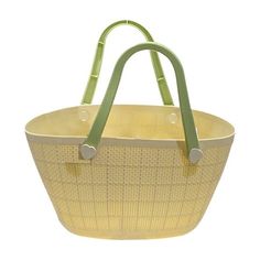 a large yellow basket with green handles on a white background, it is also used as a purse or tote bag