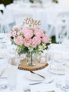 the table is set with wine glasses and flowers