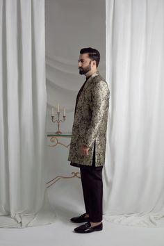 Upgrade your style with our Black and Gold Prince Coat. Made from luxurious brocade material, this front open coat exudes royalty. Paired with an Indian raw silk kurta pajama, it's the perfect ensemble for any formal event. Elevate your look and make a statement with this unique and elegant piece. 3-Piece Suit Elegant Semi-formal Sets For Eid, Elegant Silk Sherwani With Resham Embroidery, Elegant Suits With Resham Embroidery, Elegant Raw Silk Sherwani Straight Kurta, Elegant Sherwani In Raw Silk With Straight Kurta, Elegant Bandhgala With Naqshi In Raw Silk, Elegant Raw Silk Bandhgala With Naqshi, Luxury Brocade Suit For Formal Occasions, Elegant Nehru Jacket With Resham Embroidery For Designer Wear