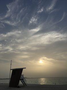 the sun is setting over the ocean with clouds in the sky