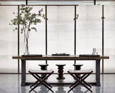 a dining room table with four chairs and a vase