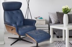 a blue leather recliner chair and footstool in a living room with white walls