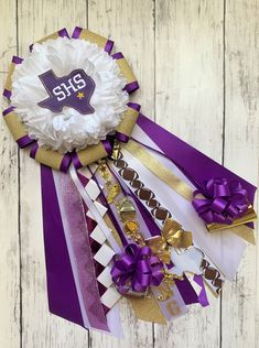 a purple and white ribbon with the number six on it next to some other ribbons