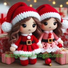 two crocheted dolls sitting next to each other on a table with christmas decorations