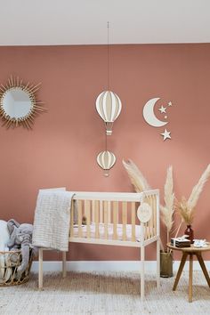 a baby's room with hot air balloons and other decorations on the wall, including a crib