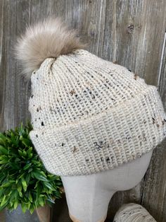 Hand stitched hats that are cozy and comfortable! This beautiful hat is cream with flecks of black and brown throughout. For every hat sold one will be donated to a homeless shelter near me. You can feel good knowing that together we are keeping people warm! These hats are made with yarn that is 97% acrylic and 3% viscose. A faux fur pom pom in a coordinating color adds that special touch. Beige Yarn Hat For Winter, Cream Crochet Hat For Fall, Cream Crochet Winter Hat With Soft Knit, Winter Cream Crochet Hat With Soft Knit, Cream Soft Knit Crochet Hat For Winter, One Size Cream Hat For Fall, Cozy Beige Crochet Hat For Fall, Cream Beanie Hat For Fall, Cream Hats For Cold Weather In Fall