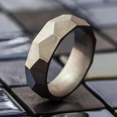 Faceted to perfection, this titanium wedding band is full of character and sleek angles. This wedding band is far from the ordinary and as unique as you are. Honor your love with a one of a kind custom designed wedding band.RING LAYOUT Ring Width: 8 mm Ring Sleeve: Titanium Ring Profile: Faceted (custom) Ring Finish: MatteTitanium Band with Custom ProfileThis ring has a comfort fit.RING FITTING:We highly recommend that you get your ring size in a COMFORT FIT measured by reputable jewelers UNTIL Titanium Wedding Rings With Polished Finish, Wedding Titanium Rings With Polished Finish, Silver Titanium Wedding Rings, Modern Stainless Steel Wedding Rings, Minimalist Titanium Jewelry For Anniversary, Minimalist Titanium Rings For Anniversary, Wedding Band For Men, Titanium Wedding Band, Unique Wedding Bands