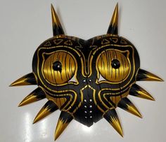 a mask with spikes on it sitting on top of a white table next to a wall