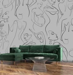 a green couch sitting in front of a drawing on the wall