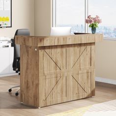 a wooden desk with a laptop on top of it in front of a large window