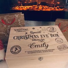 two christmas eve boxes sitting next to a fireplace