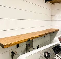 a washer and dryer in a room with wood planks on the wall