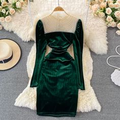 Immerse yourself in the luxury of velvet with this enchanting emerald green dress. The rich texture of the fabric is complemented by the elegant pearl beadwork that adorns the neckline, adding a touch of sophistication and vintage charm. The round neckline provides a modest canvas for the intricate pearls, making this dress a standout piece for any formal event.The dress features long sleeves and a fitted bodice that gracefully transitions into a slightly flared skirt, echoing the timeless desig Green Velvet Dress For Fall, Elegant Long Sleeve Winter Dress, Elegant Fitted Dark Green Mini Dress, Green Velvet Fall Dress, Chic Dark Green Formal Dress, Chic Dark Green Evening Dress, Elegant Long Sleeve Velvet Dress, Elegant Fitted Velvet Dress, Elegant Velvet Dress For Fall