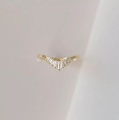 a gold ring with three baguettes on it's side, set against a white background