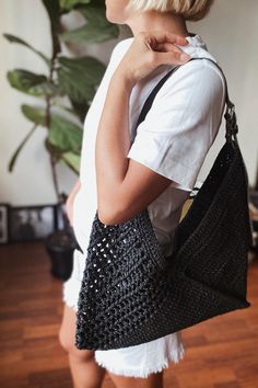 a woman carrying a black purse on her shoulder