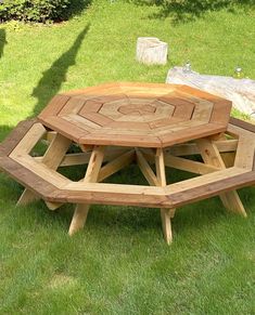 a wooden table sitting on top of a lush green field