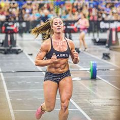 a woman running on a track in front of an audience