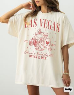 a woman wearing a white las vegas t - shirt with pink lettering on the front