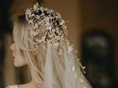 a woman wearing a veil with flowers on it