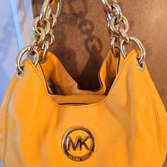 This Absolutely Stunning Michael Kors Fulton Chain Leather Medium Vintage Shoulder Tote Comes In The Most Beautiful Deep Sunset Yellow/Orange Color And Pairs With The Gold Polished Hardware In A Stunning Way! It Is Brand New, Without Tags And In Truly Mint Condition. It Is Crafted With The Most Soft And Luxurious Pebbled Leather And Features A Trio Of Interior Compartments To Keep Your Items Organized And Easy To Find. The Closures Are Two Magnetic Clasps On The Front And Back With A Zippered Cl Yellow Michael Kors Leather Shoulder Bag, Michael Kors Yellow Leather Shoulder Bag, Yellow Shoulder Bag With Chain Strap For Travel, Yellow Leather Bag With Chain Strap, Deep Sunset, Sunset Yellow, Gold Tote Bag, Michael Kors Bedford, Brown Leather Crossbody Bag