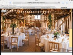 the inside of a barn with tables and chairs set up for an elegant wedding reception